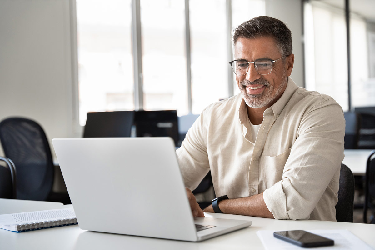 a smiling man using a laptop