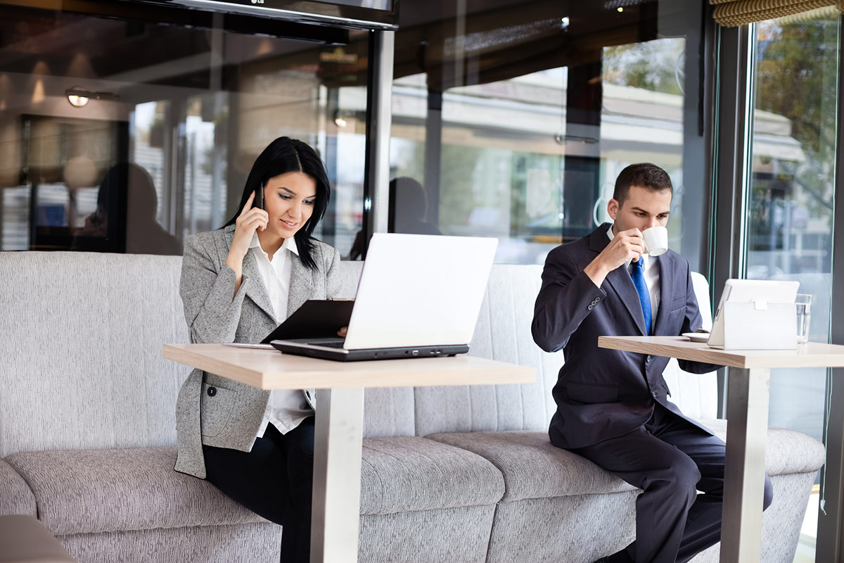 a woman and a man using laptops in a coworking space